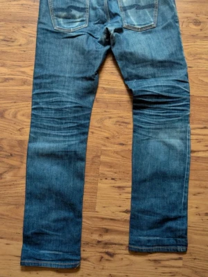 Nudie jeans  - Snygga blåa nudie Grim Tim jeans med snygga fades  | Kanon skick | Modellen på bilden är 182 och väger 70 kg | P105