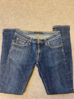 Blå jeans från Nudie  - Säljer ett par klassiska blå jeans från Nudie. Perfekta för en avslappnad stil. OBS färgen på första bilden blev konstig! Den är inte lika ljus upptill.