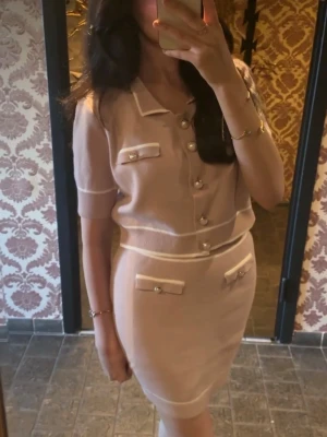 Ljusrosa Set med pärlknappar - Supersöt med korta ärmar och dekorativa pärlknappar framtill. Klänningen har vita detaljer vid krage, ärmslut och fickor samt fejkfickor med pärldetaljer. Figurnära passform och mjukt stickat material.