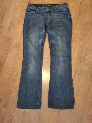 Grå bootcut jeans  - Säljer ett par klassiska grå bootcut jeans från soelle med fem fickor och snygga  rosa sömmar på bakfickorna. Jeansen har normal passform och är tillverkade i bomull, perfekta för en avslappnad och trendig look.