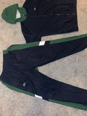 Lacoste Tracksuit Nyskick - Hej, säljer min Lacoste tracksuit som jag fick i present men passar inte mig. Den har använts ungefär 3 gånger men den passade inte så den är i helt ny skick typ. Storleken är XS men kan passa S.