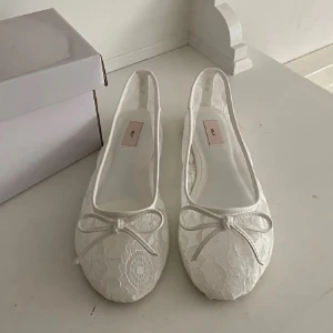 Ballerinaskor med spets - Säljer ett par vita ballerinaskor med vacker spets och söt rosett framtill eftersom de var väldigt stora i storlek. Kommer i originalbox.🤍🩰