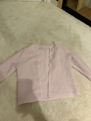 Ljusrosa ribbad kofta Stockholm LM - Söt ljusrosa kofta från Max Mara i ribbad bomullsmix. Koftan har rund halsringning, knäppning framtill och diskret logodetalj på ärmen. Perfekt att slänga över en topp för en chill look. Skriv för frågor osv🥰