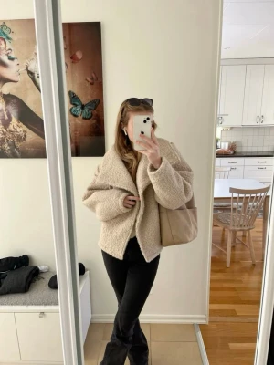 Beige oversized teddyjacka - Mysig och trendig teddyjacka i beige med oversized passform och stora slag. Jackan har dubbelknäppning framtill och är gjord i fluffigt teddy-material som ger en cool och avslappnad look. Perfekt för dig som vill ha en varm och stylish jacka till hösten eller vintern. Aldrig använd🤎