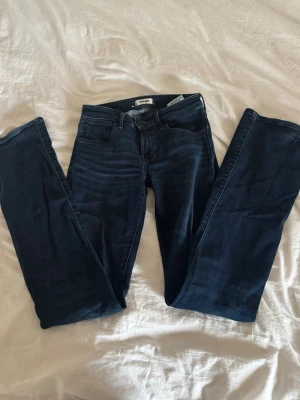 Mörkblå Bootcut jeans från Wrangler - Snygga mörkblå Bootcut jeans från Wrangler med klassisk femficksdesign och mellanhög midja. Jeansen har stretchigt material för extra komfort och en smickrande passform. Perfekta till vardagslooken och lätta att matcha med olika stilar. De är endast testade💕