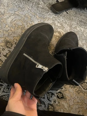 Svarta stövletter med dragkedja - Säljer ett par svarta stövletter från Race Marine. De har en chunky sula och en snygg silverfärgad dragkedja på sidan. Materialet är mocka eller mockaimitation som ger en stilren look. Perfekta till höstens outfits!