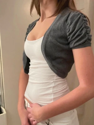 Jättesöt bolero med puffärm - Kort bolero i mörkgrått från H&M i storlek XS, men passar också som S. Passar jättebra som en liten extra touch till ens outfit!🤍