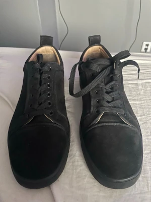 Svarta låga sneakers i mocka - Stilrena svarta sneakers i mocka med lågt skaft och svarta skosnören. Klassisk design med diskreta sömmar och svart sula. Perfekta för dig som gillar en clean look och vill ha något som funkar till det mesta. Sulan har släppt, men funkar att super limma..!