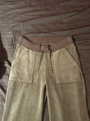 ljusgröna Juicy Couture byxor - Säljer ett par ljusgröna byxor från Juicy Couture i velour med guldiga metalldetaljer. Byxorna är köpta på Juicy Coutures egna hemsida för 1200kr. Varsamt använda. Inga defekter. 