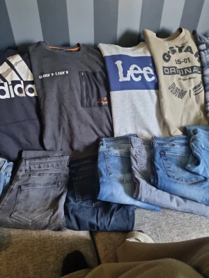 Blå och grå jeans i olika tvättar + tröjor - Säljer flera par jeans i olika blå och grå nyanser. Klassisk femficksmodell med raka ben och normal midja. Jeansen är tillverkade i denim och passar perfekt till en avslappnad stil. Åtta st tröjor oxå =) I samma paket =) 