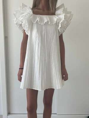 Vit plisserad volangklänning från Zara - Populär och eftertraktad klänning från Zara!! ❤️❤️ så fin till student och liknande