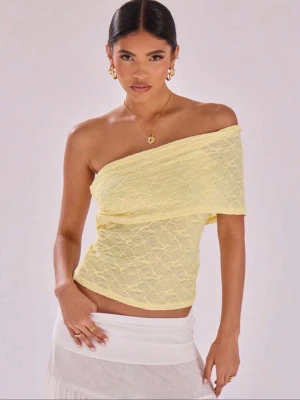 Gul spetsig oneshoulder topp - Trendig gul topp i spets med oneshoulder-design och axelbandslös passform. Tunn och lätt, perfekt för varma dagar. Snyggt omlottlagd framtill för extra detalj. Passar dig som vill sticka ut med en fräsch och somrig vibe. Aldrig använt, prislapp på. Pris kan diskuteras.