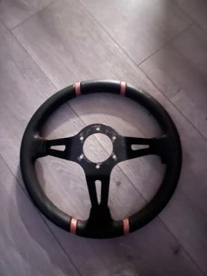Mr tuning Sportratt - Säljer en svart sport-ratt med tre ekrar i metall och grepp i läder. Ratten har två röda markeringar upptill och nedtill för racingkänsla. Passar till bilbygge eller simulator. Monteringshål i mitten för enkel installation.