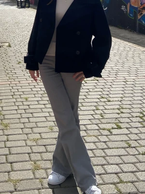 Grå bootcut byxor  - Snygga grå bootcut byxor i mjukt bomullsmaterial. Byxorna har en klassisk passform med utsvängda ben och midwaist. Perfekta för dig som vill ha en clean och stilren look till vardags. Matcha med sneakers eller boots för en chill vibe.