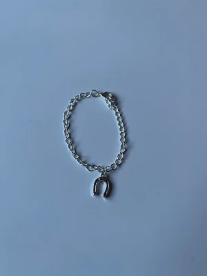 Kedje armband med hästsko  -  Här är ett kedje armband med en hästsko i silver, men finns även i guld på andra bilden. Armbandet har ett knäppe och dom är handgjorda.