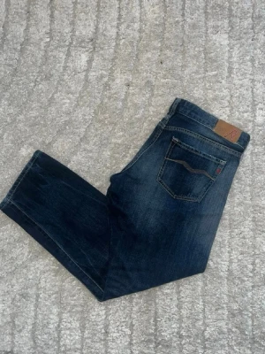 Replay jeans  - Mörkblåa jeans från Repaly med en snygg fade. Midja 41cm, längd 88cm. Obs jeansen har små defekter - se bild. JAG SKICKAR EJ FLER BILDER NÄR JAG BÄR JEANSEN! för bättre inblick i passformen rekommenderar jag att googla på modellnamnet. För storleksguide kolla måtten noggrant då jeansen alltid kan vara uppsydda heller krympta och jag ej tar emot returer :) s6,5