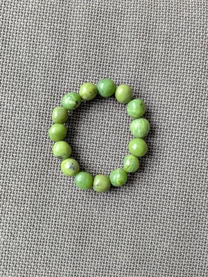 Grönt pärlarmband sten - Snyggt armband med runda gröna pärlor gjord av äkta sten på elastisk tråd. Kan bli dock kallt på armleden då det är sten. Köpt på Busfrö