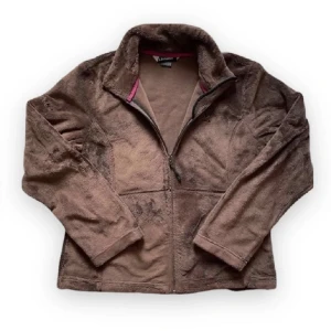 Brun fleecejacka - Mysig brun fleecejacka från Schōffel med hög krage och dragkedja framtill. Jackan har långa ärmar och två sidofickor! 