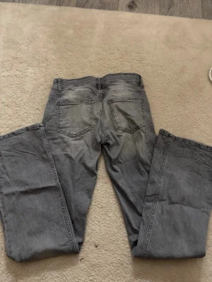 Lowwaist Bootcut gråa jeans - Lowwaist Bootcut gråa jeans från Kappahl,knappt använda,behöver bara strykas. Jätte fint och bra skick,inga defekter. Kan strykas innan packning om så önskas💕🤗skriv vid frågor💕🤗