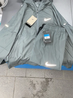 Nike miller windbreaker tracksuit running (reflective) - Nike set i grå färg, helt ny med lapprna på,  Size M‼️ fraktar samma dag eller morgonen efter✅