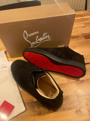 Svarta sneakers från Christian Louboutin - Snygga svarta sneakers från Christian Louboutin med klassisk röd sula. Helt nya aldrig använda 10/10 skick. Alla tillbehör medföljer. Pris kan diskuteras vid snabb affär. Storlek 43. Hög efterfrågan säljer slut snabbt!