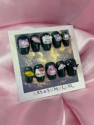 HarajukuNight (S);Short Ballerina - Set med handgjorda mörkgröna press-on naglar dekorerade med söta 3D Sanrio figurer som Hello Kitty, My Melody och Kuromi. Naglarna har en glansig finish och en ballerina, kort form. Perfekt för dig som vill ha gulliga och unika naglar med extra detaljer.S: 15 mm, 11,5 mm, 12 mm, 11 mm, 9 mm 