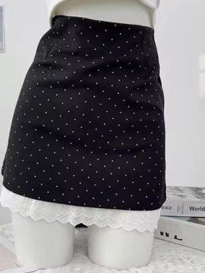 Svart prickig minikjol med spetskant - Midja mått 62.