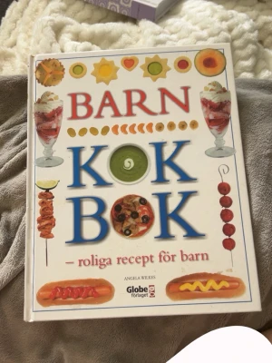 Barnkokbok – roliga recept för barn - En färgglad och inspirerande kokbok för barn. Lite synliga tecken på omslagen, men boken har tillhört ett barn så hoppas det är okej men insidan så är den mycket bra skick och inget kladd. Det är bra och tydliga instruktioner för barn och för nybörjare.