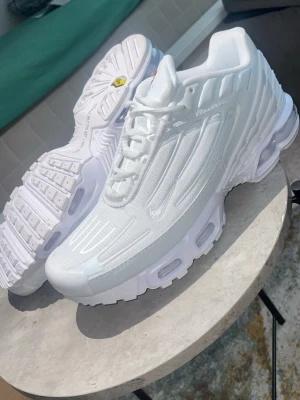Nike Air Max Plus vita sneakers - Fräscha vita Nike Air Max Plus sneakers med Tn-detaljer på plösen och sulan. Skorna har en chunky sula med synliga Air Max-enheter och ovandel i mesh och syntet. Snygga detaljer och klassisk siluett som sticker ut.