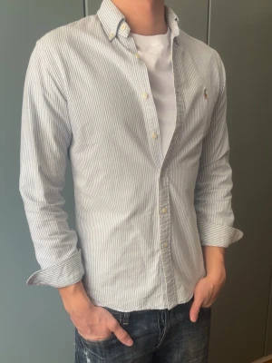 Randig skjorta från Ralph Lauren - Skjorta från Ralph Lauren, inga defekter. Modellen är 187 cm, väger 80 kg och brukar klä i M.  Storlek på skjorta S/P   Leverans sker dagen efter senast. Skriv om du har nån fråga✨