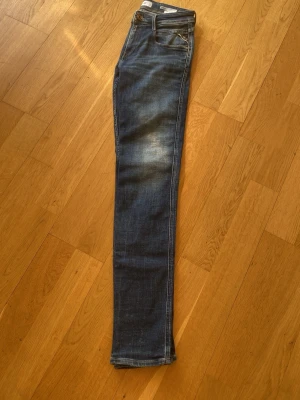 Mörkblå slim fit jeans - Säljer ett par mörkblå skinny jeans med snygga slitningar och tvättade detaljer på låren. Klassisk femficksmodell med knapp och dragkedja. Jeansen har smal passform och är perfekta för en trendig vardagslook.