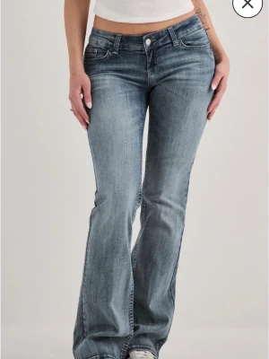 Bootcut jeans i gråblå tvätt - Bootcut jeans med gråblå tvätt och klassisk femficksdesign. Jeansen har en låg midja. Materialet är denim och passformen är något utsvängd nedtill. Perfekta för dig som gillar en avslappnad och trendig stil. Knappt använda. Skriv vid frågor 🥰