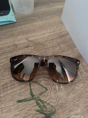 Ray-Ban Wayfarer solglasögon leopard - Snygga Ray-Ban Wayfarer solglasögon med leopardmönstrad båge i bruna och gula toner. Klassisk fyrkantig form och mörka glas. Perfekta för att lyfta din stil under soliga dagar.