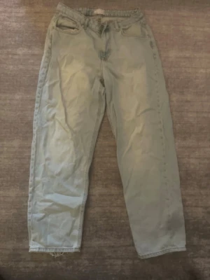 Asos ljusblå jeans - Jeansen har en avslappnad look med normal midja och dragkedjegylf. Perfekta för en chill och avslappnad stil. Materialet är denim i bomull.