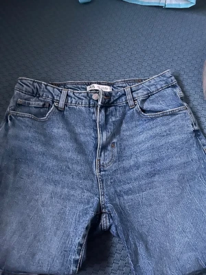 Blå raka jeansshorts från Zara - Ett par klassiska blå jeansshorts från Zara med rak passform och fem fickor. Tillverkade i denim såklart och sommaren är snart i full fart så för er herrar som vill passa på och skaffa sköna sommar jeansshorts så kan vi lösa affär!