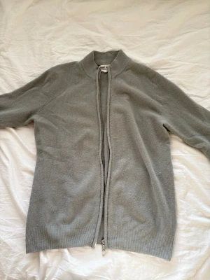 Ljusgrön cardigan SOFT GOAT, strlk: S - En stilren ljusgrön cardigan med dragkedja framtill och ribbad krage. Jackan har långa ärmar och är tillverkad i kashmir. Perfekt för lager på lager och enkel att matcha med olika outfits. 