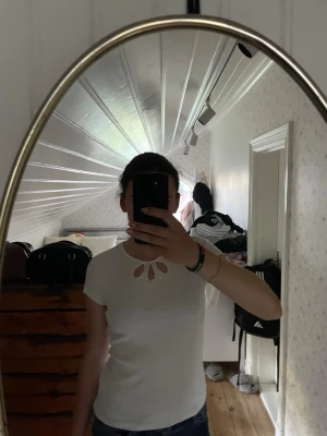 Vit ribbad t-shirt med cut out-detalj - Säljer en vit ribbad t-shirt från Lindex med korta ärmar och snygga cut out-detaljer vid halsringningen. T-shirten har en figurnära passform och är gjord i mjuk bomull, perfekt till jeans eller kjol. Passar perfekt till sommaren också.