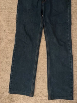 Levis jeans 501 - Säljer ett par klassiska mörkblå jeans med rak passform. Jeansen har fem fickor och stängs med knapp och dragkedja. Perfekta till en avslappnad stil och funkar året runt. Materialet är denim i bomull. Skick 9/10 använda fåtal gånger men fortfarande i mycket god skick. Storlek w31 L32