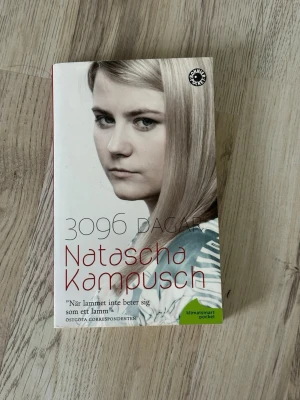 3096 dagar av Natascha Kampusch - En gripande pocketbok med vit framsida och röd text, skriven av Natascha Kampusch. Boken berättar om hennes upplevelser under åtta års fångenskap och ger en unik inblick i psykologi och överlevnad. Perfekt för dig som gillar verklighetsbaserade berättelser.