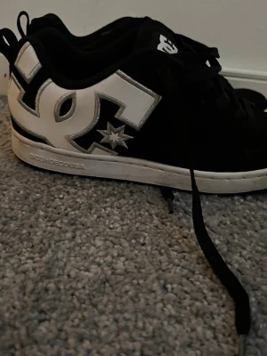 Svarta DC sneakers med vit logga - Svarta sneakers från DC Shoes med stor vit DC-logga på sidan och silvriga detaljer. Använt ca 15 gånger, storlek 39 men liten i storlek. Priset kan diskuteras💕💕