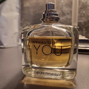 Because It's You från Emporio Armani - Elegant parfymflaska med en gyllene doftvätska. Flaskan har en stilren design med texten 'Because It's You' på framsidan och Emporio Armani-loggan nedtill. Perfekt för den som söker en sofistikerad och modern doft. Se bild för mängd som är kvar. Utan kork. Köpt på Kicks för 1400
