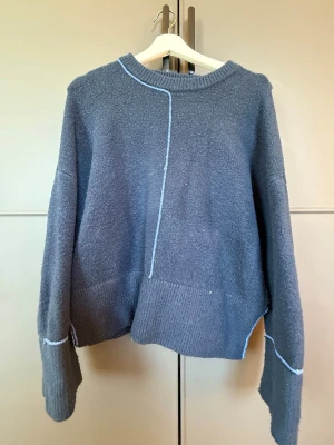 Blå oversized stickad tröja - Mysig blå stickad tröja med oversized passform och dekorativa ljusblå sömmar. Tröjan har rund halsringning, långa ärmar och bred ribbstickad nederkant. Perfekt för lager på lager och chill stil💙💙