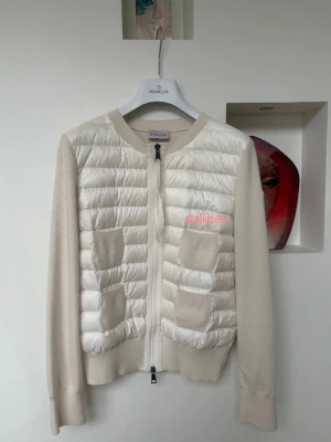 Moncler Cardigan  - Vit cardigan från Moncler i storlek S, normal i storleken. Med dragkedja framtill, två bröstfickor, quiltad framsida samt släta ärmar och rygg.  Kommer med originalförpackning och kvitto. I nyskick. Kan skickas eller hämtas upp. Pris kan diskuteras vid snabb affär.