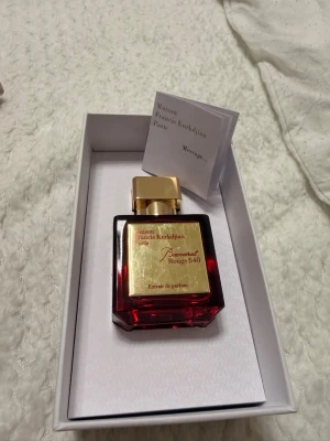 Maison Francis Kurkdjian Baccarat Rouge 540 Extrait de Parfum - Säljer en exklusiv och eftertraktad lyxparfym – Baccarat Rouge 540 Extrait de Parfum från Maison Francis Kurkdjian. 70ML  Detta är den mer intensiva och koncentrerade versionen av den ikoniska Baccarat Rouge 540. En elegant och sofistikerad doft med en unik kombination av bittermandel, saffran, jasmin, cederträ, mysk och ambergris som ger en varm, sensuell och långvarig doftupplevelse. 