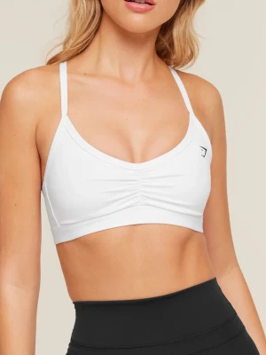 Vit sport-bh från Gymshark - Snygg vit sport-bh från Gymshark med tunna axelband och unik ryggdesign med flera band. Bh:n har lätt rynkning framtill och är tillverkad i ett stretchigt, mjukt material som passar perfekt för träning och yoga. Strl XS, liten i storlek! Fint skick 150kr+frakt🤍