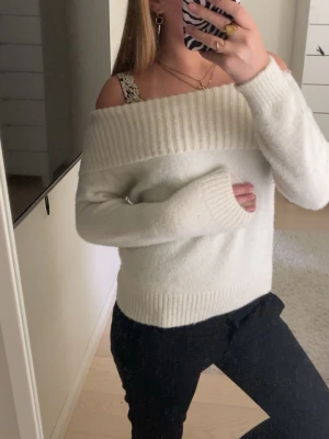 Off shoulder vit stickad tröja - (Storlek 134-140 men passar XXs) Säljer en supermjuk off shoulder stickad tröja i vitt. Tröjan har bred ribbad kant upptill och vid ärmslut samt nederkant. Perfekt för dig som gillar en avslappnad men ändå trendig look. Materialet känns fluffigt och mysigt. Inga defekter. 