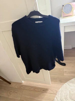 Mörkblå  stickad tröja - Mysig mörkblå stickad tröj. Tröjan är trekvarts och mjukt material som passar perfekt för kyligare dagar. Enkel och stilren design som är lätt att matcha.