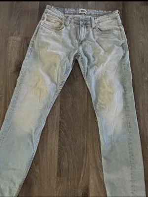 Ljusblå jeans från 157 - Säljer ett par ljusblå jeans från 157 med klassisk femficksmodell och raka ben. Jeansen har en snygg tvättad look och är tillverkade i denim. Perfekta för en avslappnad stil. Är nån svart prick där jag pekar men går säkert bort.
