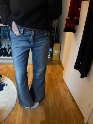 Low flare boot  - Säljer ett par blå bootcut jeans med låg midja och klassisk femficksdesign. Jeansen har en lätt tvättad look och vida ben som ger en retrovibe. Perfekta för dig som gillar en avslappnad men trendig stil. Materialet är denim i bomull. Storlek 25/au7 skulle säga som 36/38 uppsydda jag är ca 170 