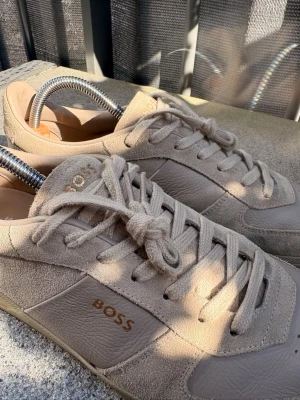 Boss Brenta sneakers - Säljer ett par Boss Brenta sneakers i storlek 43. Fint läder och mocka i beige färg.